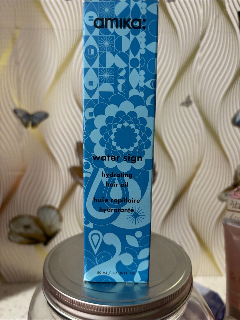 amika Water Sign Hydrating Hair Oil — blue patterned box